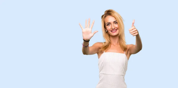 Молода Блондинка Рахує Шість Пальцями Над Ізольованим Синім Тлом — стокове фото