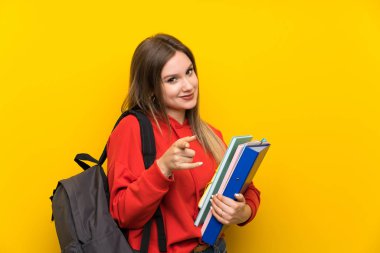 Size sarı arka plan noktaları parmak üzerinde Genç öğrenci kız
