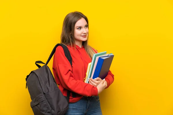 Yan Bakarak Sarı Arka Plan Üzerinde Genç Öğrenci Kız — Stok fotoğraf