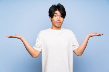 Izole mavi arka plan üzerinde Asyalı adam yüz ifadesi karıştırmayın ile şüpheleri olan