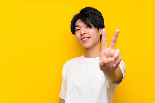 Asian Man Isolated Yellow Wall Smiling Showing Victory Sign — Stock Photo, Image