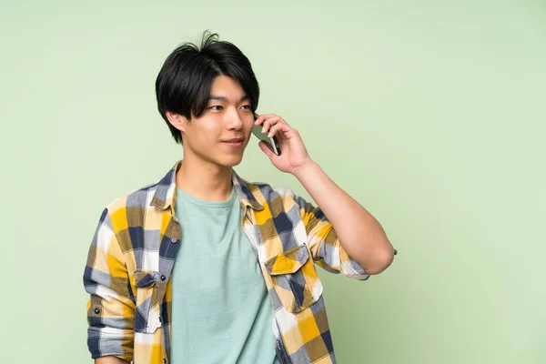 Азіатська Людина Над Ізольованою Зеленою Стіною Допомогою Мобільного Телефону — стокове фото