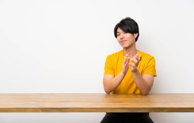 Sarı gömlekli Asyalı adam bir konferansta sunum dan sonra alkışlıyor