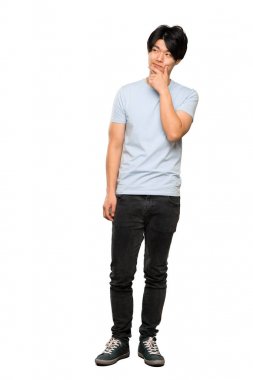 İzole beyaz arka plan üzerinde düşünme mavi gömlekli Asyalı bir adamın tam uzunlukta bir çekim