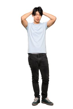 Mavi gömlek sinirli bir Asyalı adam tam uzunlukta bir çekim sinirli ve izole beyaz arka plan üzerinde baş ellerini alır