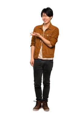 Izole beyaz arka plan üzerinde gülümseyerek bakarken kahverengi ceketli asyalı bir adamın tam uzunlukta bir çekim