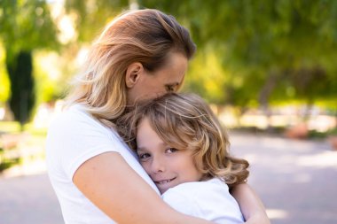 Mutlu anne ve oğlu bir parkta sarılma ve sarılma