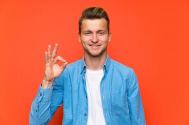 Parmakları ile ok işareti gösteren izole duvar üzerinde Sarışın yakışıklı adam