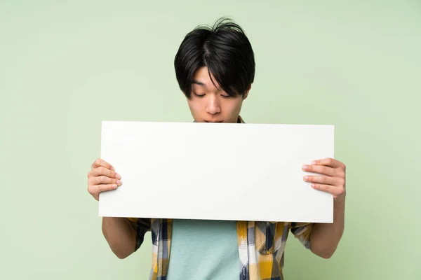 Asiatique Homme Sur Mur Vert Isolé Tenant Une Plaque Blanche — Photo