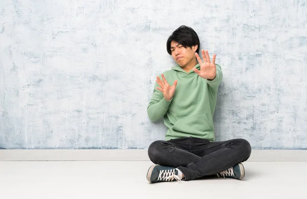 Asiatischer Mann Sitzt Nervös Auf Dem Boden Und Streckt Die — Stockfoto