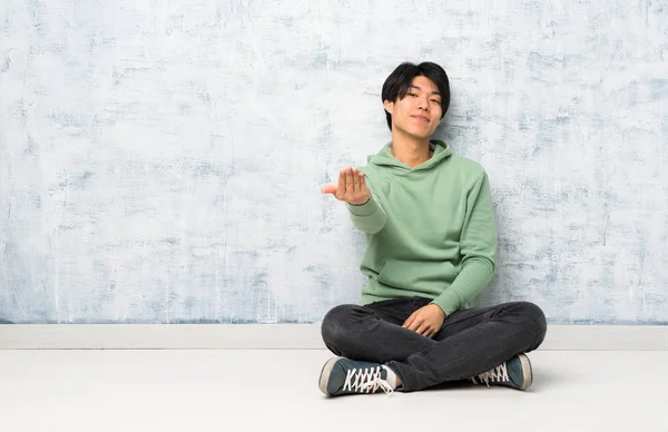 Asiatischer Mann Der Auf Dem Boden Sitzt Und Einlädt Mit — Stockfoto