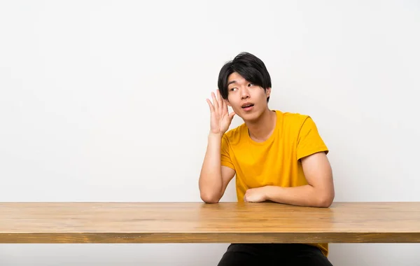 Hombre Asiático Con Camisa Amarilla Escuchando Algo Poniendo Mano Oreja — Foto de Stock