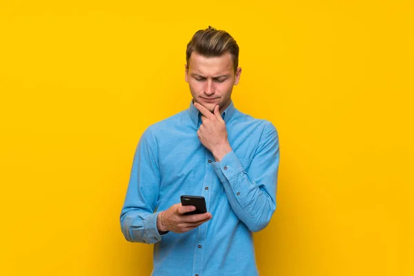 Blonde Man Isolated Yellow Wall Thinking Sending Message — Stock Photo, Image