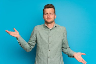 Izole mavi duvar üzerinde Sarışın adam bir şey anlamak için mutsuz