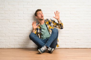 Sarışın adam sinirli ve korkmuş katta oturan