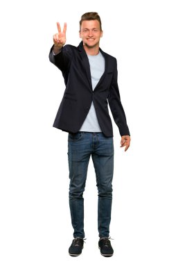 Sarışın yakışıklı adam gülümseyerek ve zafer işareti gösteren