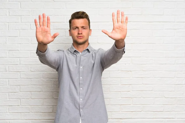 Blond Man Över Vit Tegelvägg Gör Stopp Gest Och Besviken — Stockfoto