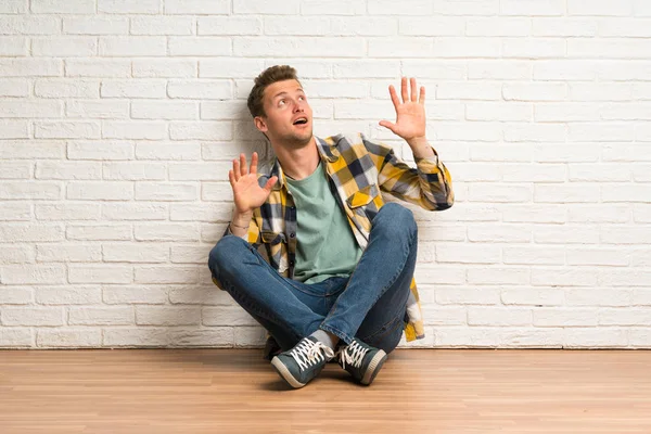 Blonder Mann Sitzt Nervös Und Verängstigt Auf Dem Boden — Stockfoto