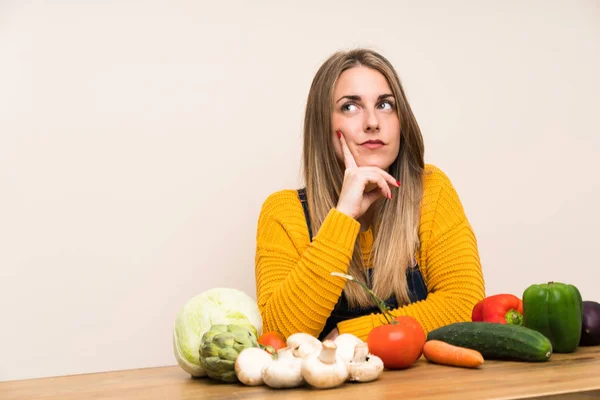 Woman with lots of vegetables thinking an idea