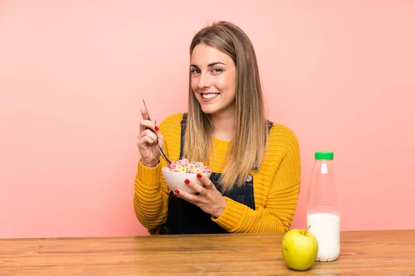 Boldog fiatal nőt tál gabonafélék több mint rózsaszín fal — Stock Fotó