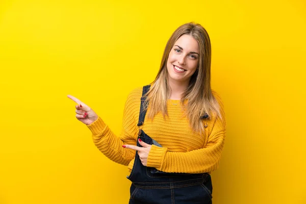 Mujer Con Mono Sobre Pared Amarilla Aislada Apuntando Con Dedo —  Fotos de Stock