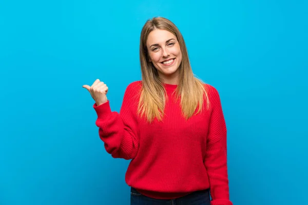 Donna Con Maglione Rosso Sopra Parete Blu Che Punta Verso — Foto Stock