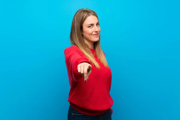 Mujer Con Suéter Rojo Sobre Pared Azul Señala Con Dedo —  Fotos de Stock