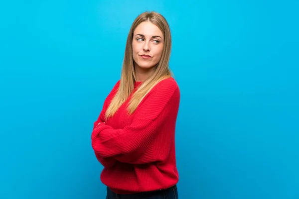 Woman with red sweater over blue wall portrait