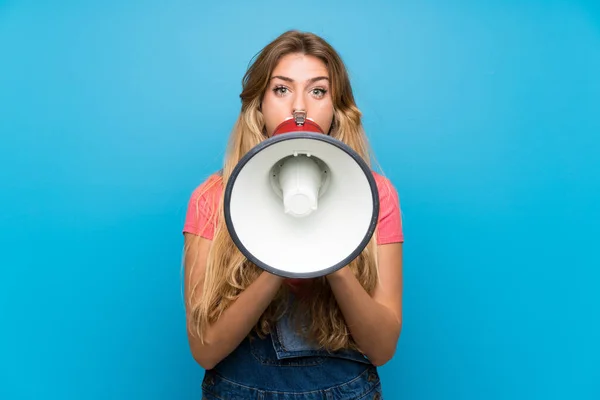 Jonge Blonde Vrouw Met Overalls Geïsoleerde Blauwe Muur Schreeuwen Door — Stockfoto