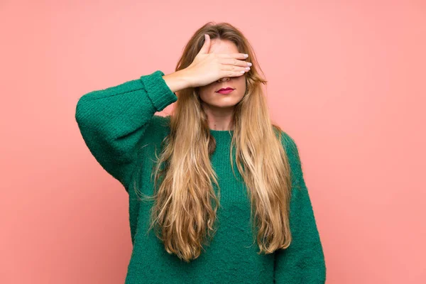 Jovem Mulher Loira Com Suéter Verde Sobre Parede Rosa Cobrindo — Fotografia de Stock