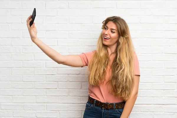 Mladé Blondýny Žena Přes Bílou Cihlovou Zeď Dělat Selfie Mobilním — Stock fotografie