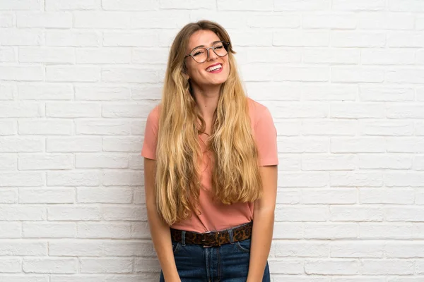 Mujer Rubia Joven Sobre Pared Ladrillo Blanco Con Gafas —  Fotos de Stock