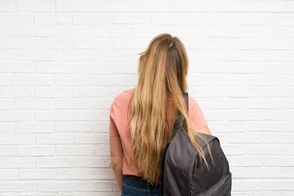 Jovem Loira Sobre Parede Tijolo Branco Com Mochila — Fotografia de Stock