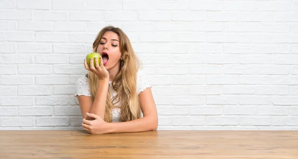Mujer rubia joven con una manzana — Foto de Stock
