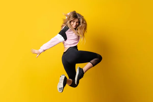 Bailarina urbana dançando sobre fundo amarelo isolado e pular — Fotografia de Stock