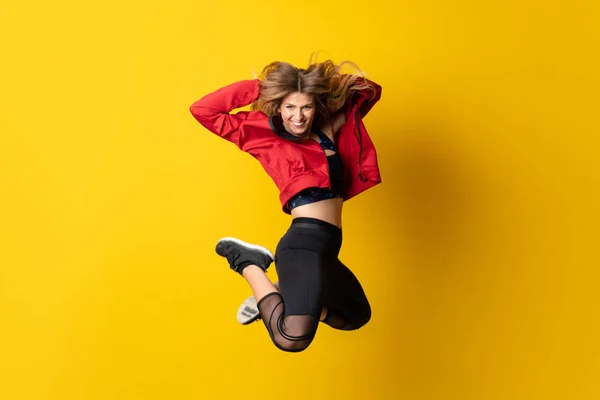 Bailarina urbana bailando sobre fondo amarillo aislado y saltando —  Fotos de Stock