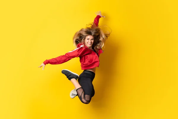Bailarina urbana bailando sobre fondo amarillo aislado y saltando — Foto de Stock