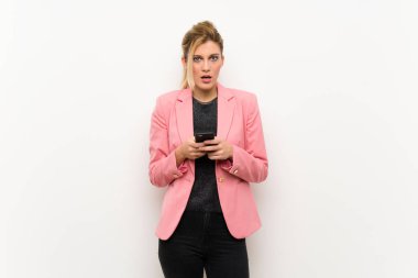 Pembe elbiseli genç sarışın kadın şaşırdı ve bir mesaj gönderiyor.