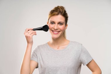 Makyaj fırçası ile genç sarışın kadın