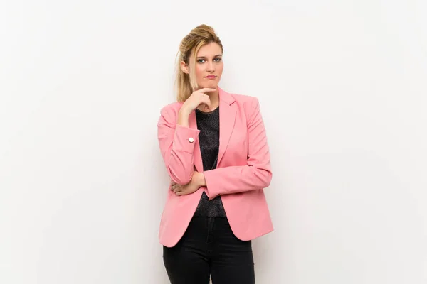 Young blonde woman with pink suit thinking