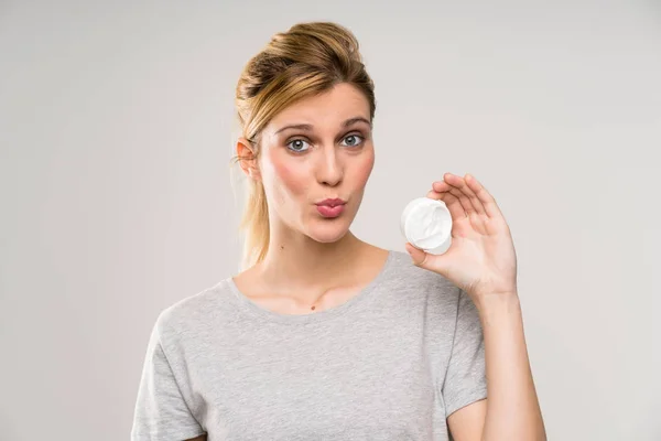 Young blonde woman with makeup brush with moisturizer