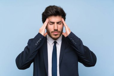 Baş ağrısı ile izole mavi duvar üzerinde Işadamı