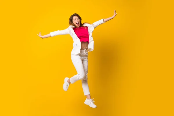 Giovane donna saltando oltre isolato muro giallo — Foto Stock