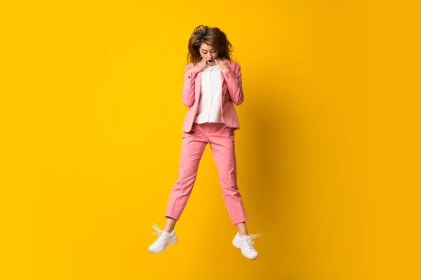 Jovem mulher saltando sobre isolado amarelo parede fazendo surpresa ges — Fotografia de Stock