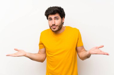 Yüz ifadesi karıştırarak şüpheleri olan izole beyaz duvar üzerinde Yakışıklı