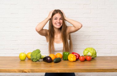 Sürpriz yüz ifadesi ile birçok sebze ile genç kadın