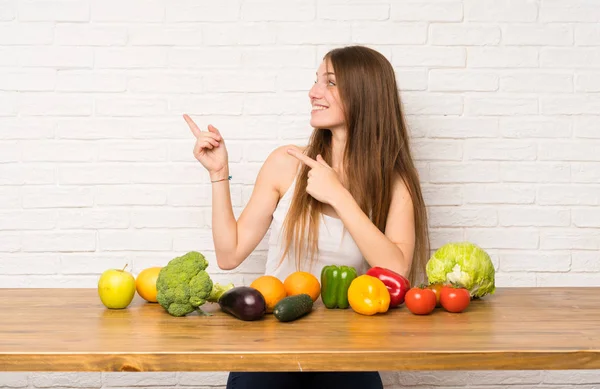 Mujer Joven Con Muchas Verduras Señalando Con Dedo Hacia Lado —  Fotos de Stock