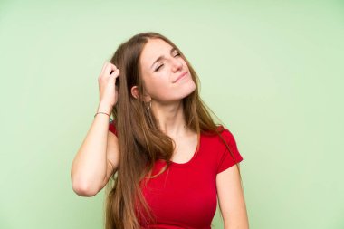 Izole yeşil duvar üzerinde uzun saçlı genç kadın şüpheleri olan ve yüz ifadesi karıştırmayın
