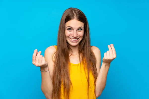 Young Woman Long Hair Isolated Blue Wall Making Money Gesture — Stock Photo, Image