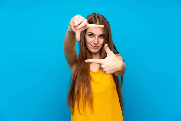 孤立した青い壁の焦点面の上に長い髪を持つ若い女性 フレーミングシンボル — ストック写真